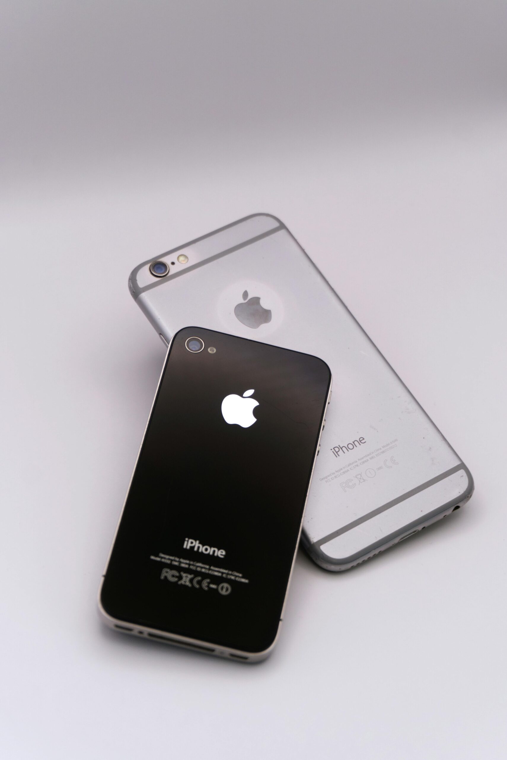 Two smartphones lying on a white surface, showcasing sleek design and advanced technology.